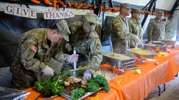 Tentara AS menyiapkan makan malam untuk merayakan Thanksgiving di perbatasan Donna, Texas, Kamis (22/11). Para tentara tetap merayakan Thanksgiving meski bertugas di perbatasan. (Senior Airman Alexandra Minor/U.S. Air Force/Department of Defense via AP)
