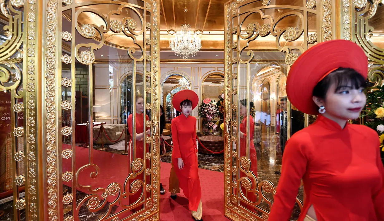 Pegawai bersiap untuk menyambut para tamu di lobi hotel Dolce Hanoi Golden Lake yang baru saja diresmikan di Hanoi, Vietnam pada Kamis (2/7/2020). Hotel tersebut merupakan hotel berlapiskan emas 24 karat pertama di dunia. (Manan VATSYAYANA / AFP)