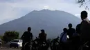 Penduduk mengamati Gunung Agung dari Desa Kubu, Kabupaten Karangasem, Bali, Rabu (11/10). Menurut BNPB, aktivitas vulkanik Gunung Agung masih tinggi sehingga PVMBG masih menetapkan status awas sejak 22 September lalu hingga saat ini. (AP/Firdia Lisnawati)