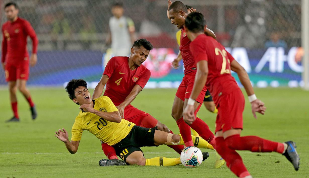 Gelandang Timnas Indonesia, Zulfiandi, menjatuhkan striker Malaysia, Muhammad Syafiq, pada laga Kualifikasi Piala Dunia 2022 di SUGBK, Jakarta, Kamis (5/9). Indonesia kalah 2-3 dari Malaysia. (Bola.com/Peksi Cahyo)