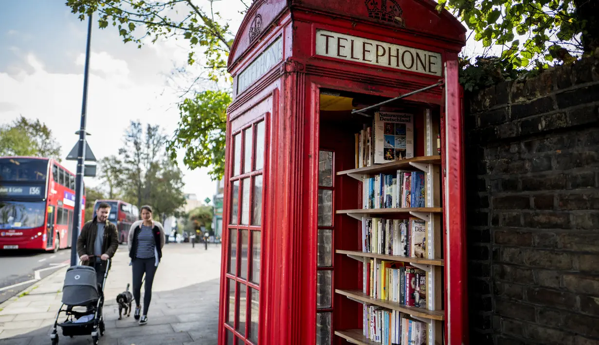 Kondisi kotak telepon merah yang kini telah berubah menjadi perpustakaan pertukaran buku di Lewisham Way, London (21/10). Menjamurnya ponsel, membuat telepon umum di Inggris ini tidak beroperasi lagi. (AFP Photo/Tolga Akmen)