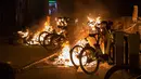 Sejumlah sepeda dibakar saat bentrokan terkait kematian seorang pedagang kaki lima di distrik Lavapies di Madrid (15/3). Pedagang bernama Mmame Mbage diduga tewas setelah dikejar-kejar aparat kepolisian. (AFP Photo/Olmo Calvo)