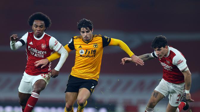 Pemain Arsenal, Willian (kiri) dan Hector Bellerin (kanan) berusaha merebut bola dari gelandang Wolverhampton Wanderers Pedro Neto pada pekan kesepuluh Liga Inggris di Emirates Stadium, London, Minggu (29/11/2020). Arsenal takluk 1-2 dari Wolverhampton Wanderers. (JULIAN FINNEY/POOL/AFP)
