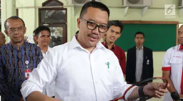 Menpora Imam Nahrawi memainkan raket bulu tangkis jelang menghadiri acara perpisahan dengan pejabat Kemenpora di Jakarta, Kamis (19/9/2019). Sebelumnya KPK menetapkan Menpora Imam Nahrawi sebagai tersangka kasus dugaan suap dana hibah KONI. (Liputan6.com/Helmi Fithriansyah)