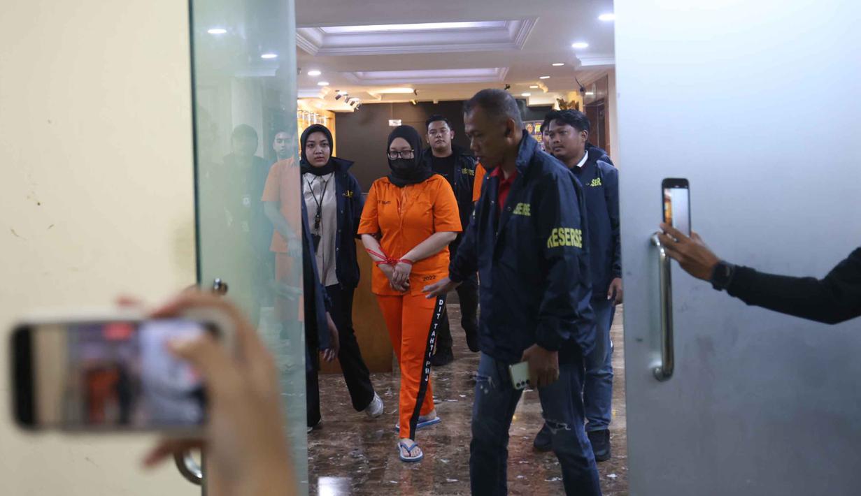 Polda Metro Jaya juga membuka posko pengaduan korban Wedding Organizer yang dikelola oleh Ayu Puspita. Tampak dalam foto, Ayu Puspita, pemilik Wedding Organizer by Ayu Puspita (tengah), digelandang petugas dari unit Kriminal Umum Polda Metro Jaya sesaat rilis di Gedung Ditreskrimum Polda Metro Jaya, Sabtu (13/12/2025). (Kapanlagi.com/Budy Santoso)