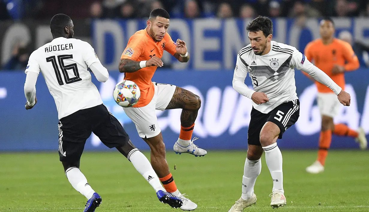 Striker Belanda, Memphis Depay, berebut bola dengan bek Jerman, Antonio Ruediger, pada laga UEFA Nations League di Veltins Arena, Gelsenkirchen, Senin (19/11/2018). Kedua tim bermain imbang 2-2. (AP/Martin Meissner)