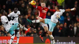 Penyerang MU, Wayne Rooney berebut bola dengan tiga pemain West Ham United di perempat final Piala Liga (EFL Cup) di Stadion Old Trafford, Inggris, (1/12). MU menang telak atas West Ham dengan skor 4-1. (Reuters/Phil Noble)