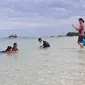 Sejumlah wisatawan menikmati liburan di Pulau Pasir alias Pulau Gusong di Belitung sebelum air pasang menyembunyikan keberadaannya. (Liputan6.com/Ady Anugrahadi)