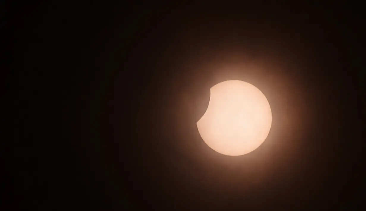 Bulan sebagian menutupi matahari selama gerhana matahari cincin (Annular Solar Eclipse) yang terlihat dari Kolombo, Sri Lanka, Minggu (21/6/2020). Sebagian penduduk Bumi bisa menyaksikan fenomena langka, Gerhana Matahari Cincin. (Photo by LAKRUWAN WANNIARACHCHI / AFP)
