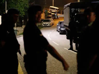 Aparat kepolisian berjaga di depan rumah mantan Perdana Menteri Malaysia, Najib Razak di Kuala Lumpur, Rabu (16/5). Polisi melakukan penggeledahan di kediaman Najib usai Salat Tarawih untuk mencari bukti dan dokumen terkait kasus 1MDB. (AP/Vincent Thian)