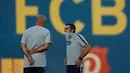 Pelatih Barcelona, Ernesto Valverde (kanan) berbincang dengan asistennya selama sesi latihan di Barcelona, Spanyol (17/9). Barcelona akan bertanding melawan PSV Eindhoven pada grup B Liga Champions di Nou Camp. (AP Photo/Manu Fernandez)