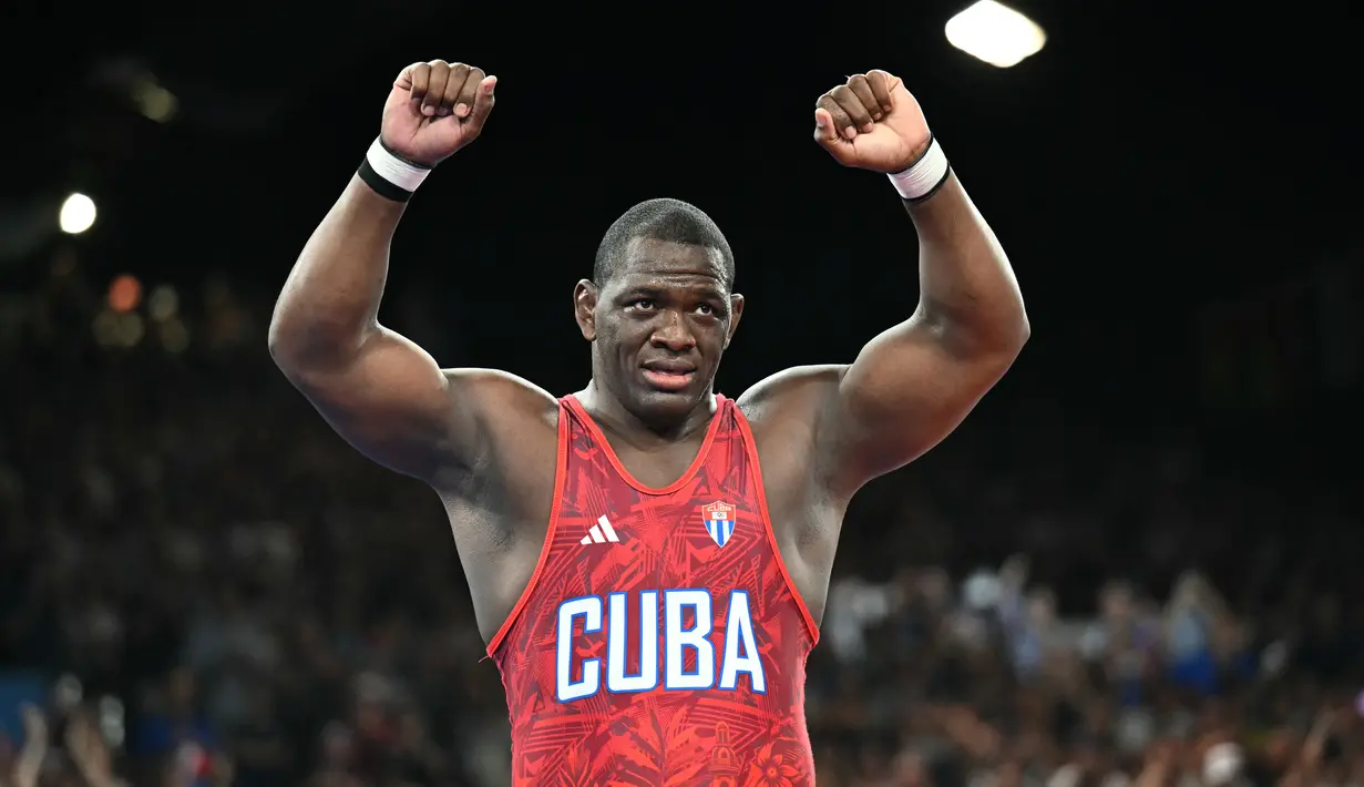 Di nomor gulat Greco-Roman 130 kg, Mijain mengalahkan wakil Chile, Yasmani Acosta, pada duel di Grand Palais Ephemere, Rabu (7/8/2024). (AFP/Punit Paranjpe)