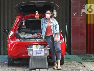 Cynthia (28) mahasiswi perguruan tinggi swasta menunggu pembeli di Jalan Santosa, Depok, Jawa Barat, Kamis (21/5/2020). Cynthia menggunakan mobil pribadinya sebagai lapak berjualan berbagai macam sayuran dengan harga serba Rp 5.000. (Liputan6.com/Herman Zakharia)