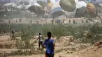 Warga Palestina bergegas menuju lokasi pendaratan paket bantuan yang diterjunkan di wilayah Nuseirat, Jalur Gaza tengah, saat penerjunan bantuan dari udara di atas wilayah Palestina yang dikepung Israel pada 6 Agustus 2025. (Eyad BABA/AFP)