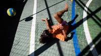Seorang anak sedang asik bermain bola voli pada program Volleyball Development Training yang digagas oleh FIVB di Formiga favela, Rio de Janeiro, (2/8/2016). (AFP/Leon Neal)