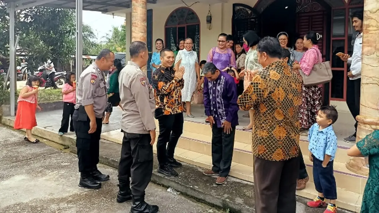 Kasat Narkoba Polresta Pekanbaru bersama polisi lainnya saat datang ke gereja mengikuti Minggu Kasih menyampaikan pesan Pemilu damai.