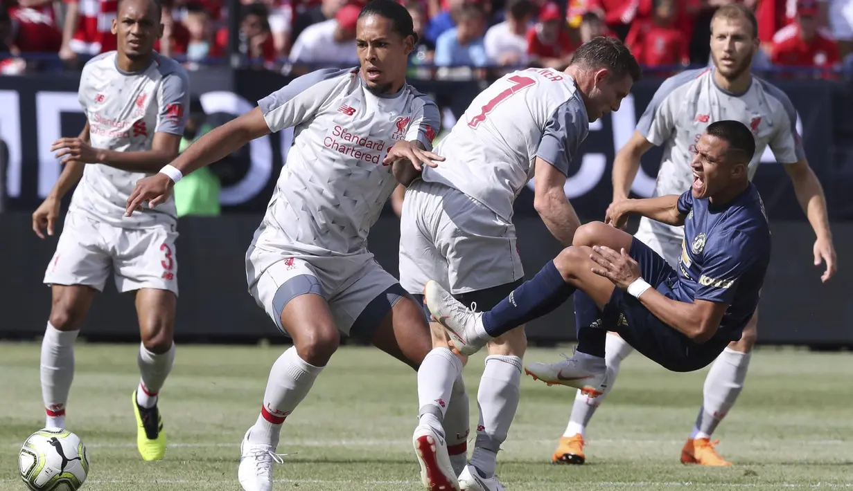 Striker Manchester United, Alexis Sanchez, terjatuh saat berebut bola dengan pemain Liverpool pada laga ICC 2018 di Stadion Ann Arbor, Michigan, Minggu (29/7/2018). Liverpool menang 4-1 atas Manchester United. (AP/Carlos Osorio)