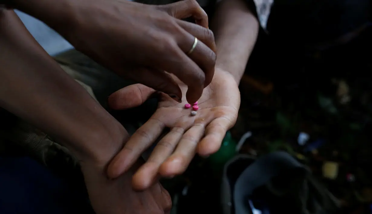 Seorang pria mengambil obat-obatan terlarang di jalanan Man Sam, Myanmar, 11 Juli 2016. Sebanyak 42 ton sabu-sabu berhasil disita oleh kantor PBB untuk Narkoba dan Kejahatan (UNODC) pada 2013. (REUTERS/Soe Zeya Tun)