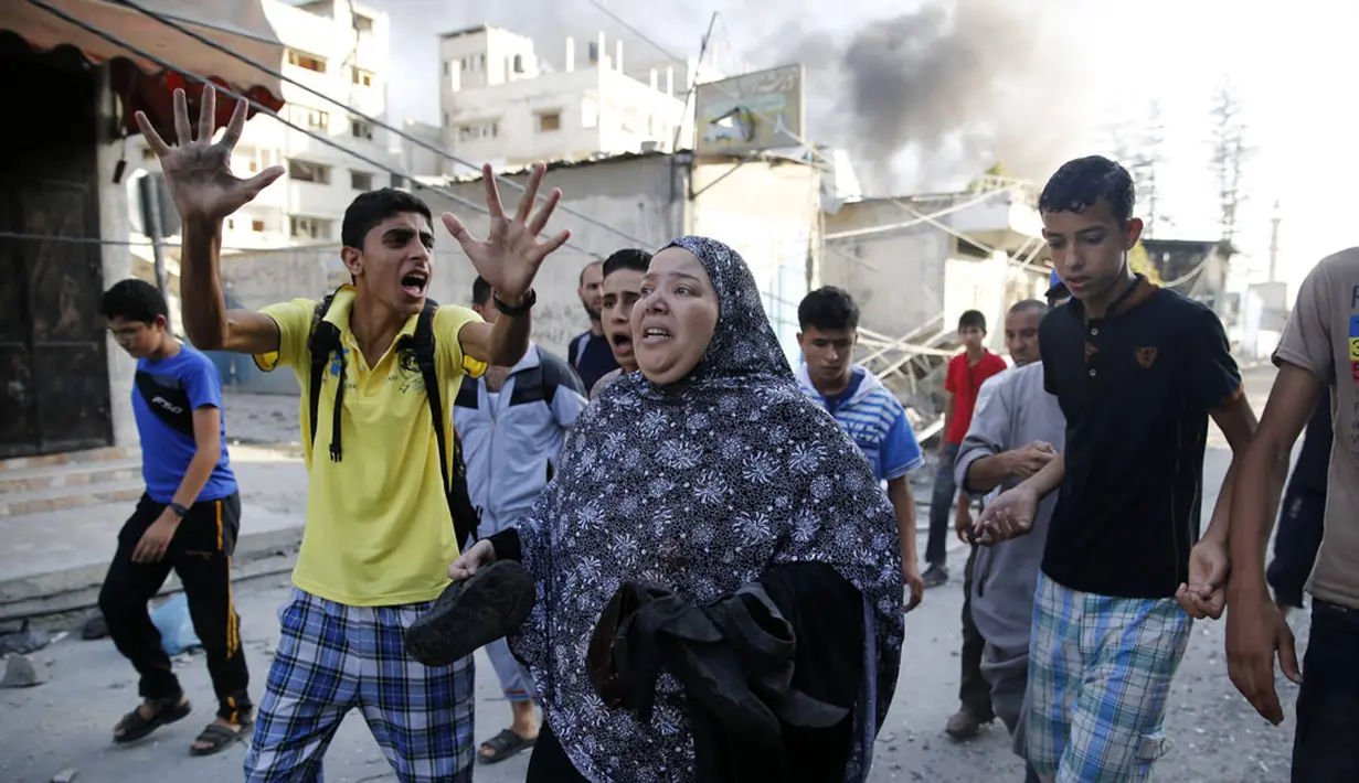 Beberapa warga melarikan diri pasca serangan udara militer Israel menghantam sebuah pasar di Shejaia, sebelah timur kota Gaza, (30/7/2014). (REUTERS/Finbarr O'Reilly)