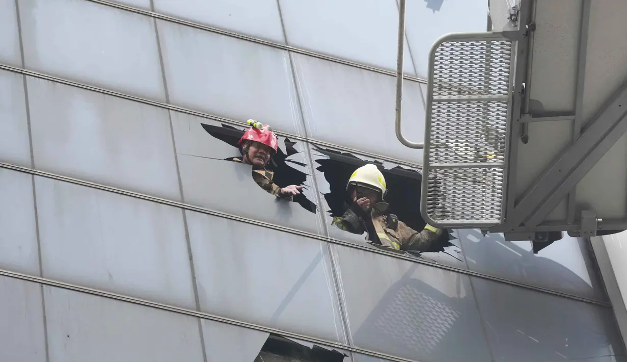Petugas pemadam kebakaran bekerja di gedung perkantoran yang terbakar di Jakarta, Selasa 9 Desember 2025. Sebanyak 20 kantong jenazah korban kebakaran Gedung Terra Drone di Kemayoran, Jakarta Pusat, telah dibawa dan tiba di Rumah Sakit (RS) Polri Kramat Jati, Jakarta Timur, pada Selasa (9/12/2025) sore. (AP Photo/Dita Alangkara)