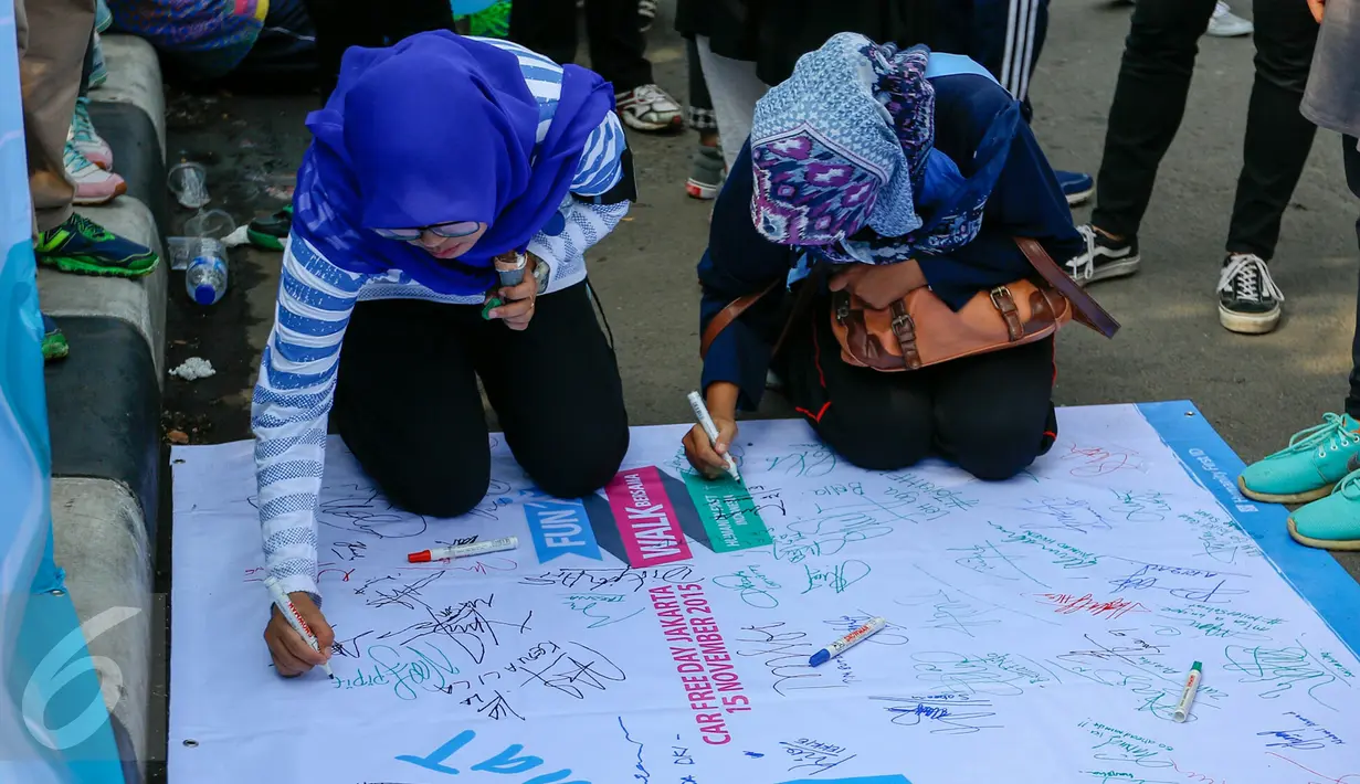 Warga membubuhkan tanda tangan mendukung sosialisasi toliet sehat di Bundaran HI, Jakarta, Minggu (15/11/2015). Dalam acara tersebut tampil sebuah maskot berbentuk kotoran manusia yang membuat suasana semakin seru. (Liputan6.com/Yoppy Renato)