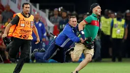 Petugas keamanan menangkap suporter yang masuk ke lapangan saat Portugal bersua Polandia pada perempat final Piala Eropa 2016 di Stade VÈlodrome, Marseille, Pranci, (30/6/2016) dini hari WIB. (REUTERS/Kai Pfaffenbach)