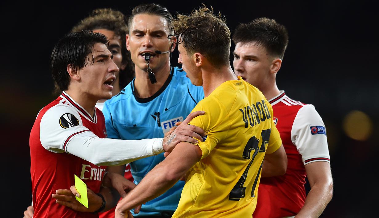 Bek Arsenal, Hector Ballerin, bersitegang dengan bek Standard Liege, Mergim Vojvoda, pada laga Liga Europa di Stadion Emirates, London, Kamis (3/10). Arsenal menang 4-0 atas Liege. (AFP/Glyn Kirk)