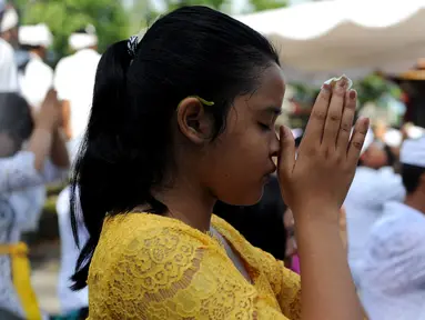 Umat Hindu berdoa saat perayaan Kuningan di sebuah pura di Pulau Serangan, Denpasar, Bali, Sabtu (20/2). Kuningan merupakan hari terakhir perayaan Galungan diyakini menjadi hari kekuasaan roh suci leluhur kembali ke langit. (AFP PHOTO/SONNY Tumbelaka)