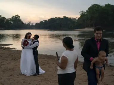 Gislaine Pereira de Araujo berpose untuk foto untuk album pernikahan bersama suaminya Ronilson de Araujo Souza dengan latar belakang hutan hujan Amazon di pantai sungai Jamanxim, di Novo Progresso, Brasil (2/9/2019). (AP Photo/Leo Correa)