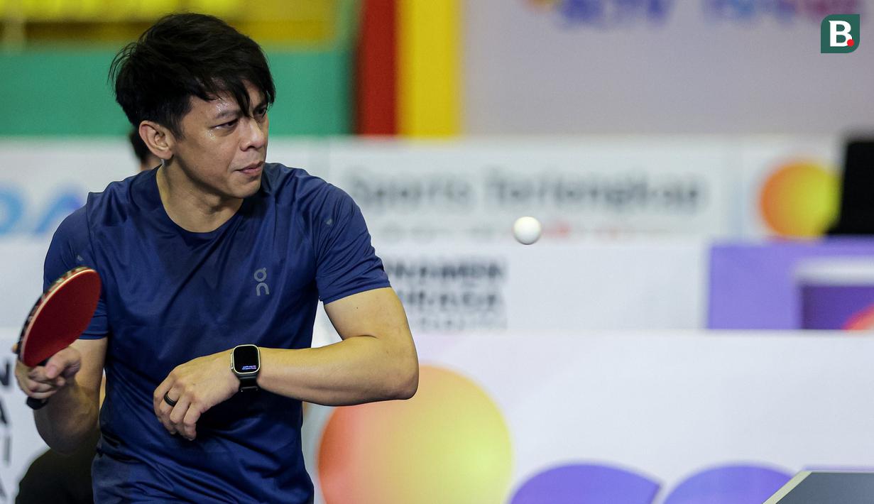 Ariel Noah yang berpasangan dengan Raffi Ahmad mengembalikan bola ke arah lawannya, pasangan Desta/Gading Marten pada laga ganda putra Turnamen Olahraga Selebriti Indonesia (TOSI) season 2 di GOR POPKI Cibubur, Jakarta Timur, Sabtu (13/01/2024). Raffi Ahmad/Ariel Noah menang 3-1 (21-10, 21-14, 17-21 dan 21-13). (Bola.com/Bagaskara Lazuardi)