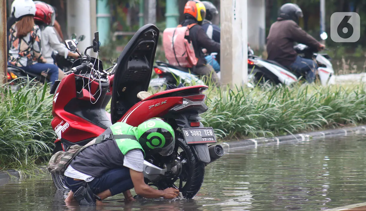 Pengendara memanfaatkan genangan air untuk mencuci kendaraan di Jalan HBR Motik Kemayoran, Jakarta, Selasa (25/2/2020). Hujan yang mengguyur Jakarta sejak Senin (24/2) malam membuat sejumlah kali meluap dan menyebabkan banjir. (Liputan6.com/Helmi Fithriansyah)