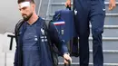 Penyerang Timnas Prancis,  Olivier Giroud dan rekan setimnya turun dari pesawat setibanya di bandara Sheremetyevo Moskow, Minggu (10/6). Giroud ikut dalam rombongan yang akan berlaga di Piala Dunia 2018 meski sedang kondisi cedera. (AP/Pavel Golovkin)