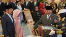 Penganugerahan itu diberikan langsung kepada ahli warisnya yang hadir di Istana, yakni Bambang Trihatmodjo dan Siti Hardijanti Rukmana. Tampak dalam foto, Presiden Indonesia Prabowo Subianto (kedua dari kanan) menyerahkan sertifikat gelar pahlawan nasional kepada putra dan putri mendiang Presiden Suharto, Siti Hardiyanti Rukmana (kedua dari kiri) dan Bambang Trihatmojo, dalam upacara pemberian gelar pahlawan nasional kepada sepuluh tokoh di Istana Negara di Jakarta, Senin 10 November 2025. (AP Photo/Achmad Ibrahim)
