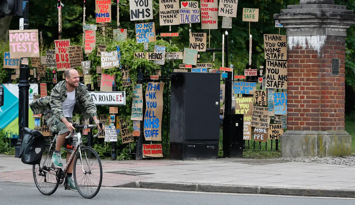 Seorang pria berjalan melewati kumpulan plakat yang dirancang oleh seniman lokal Peter Liversidge untuk mendukung Layanan Kesehatan Nasional (National Health Service/NHS) di London, Inggris, (29/4/2020). (Xinhua/Han Yan)