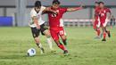 Pemain Timnas Indonesia U-17, I Komang Semadi berduel dengan pemain China U-17, Li Junpeng dalam pertandingan uji coba internasional di Indomilk Arena, Tangerang, pada Rabu (11/2/2026) malam WIB. (Bola.com/Abdul Aziz)
