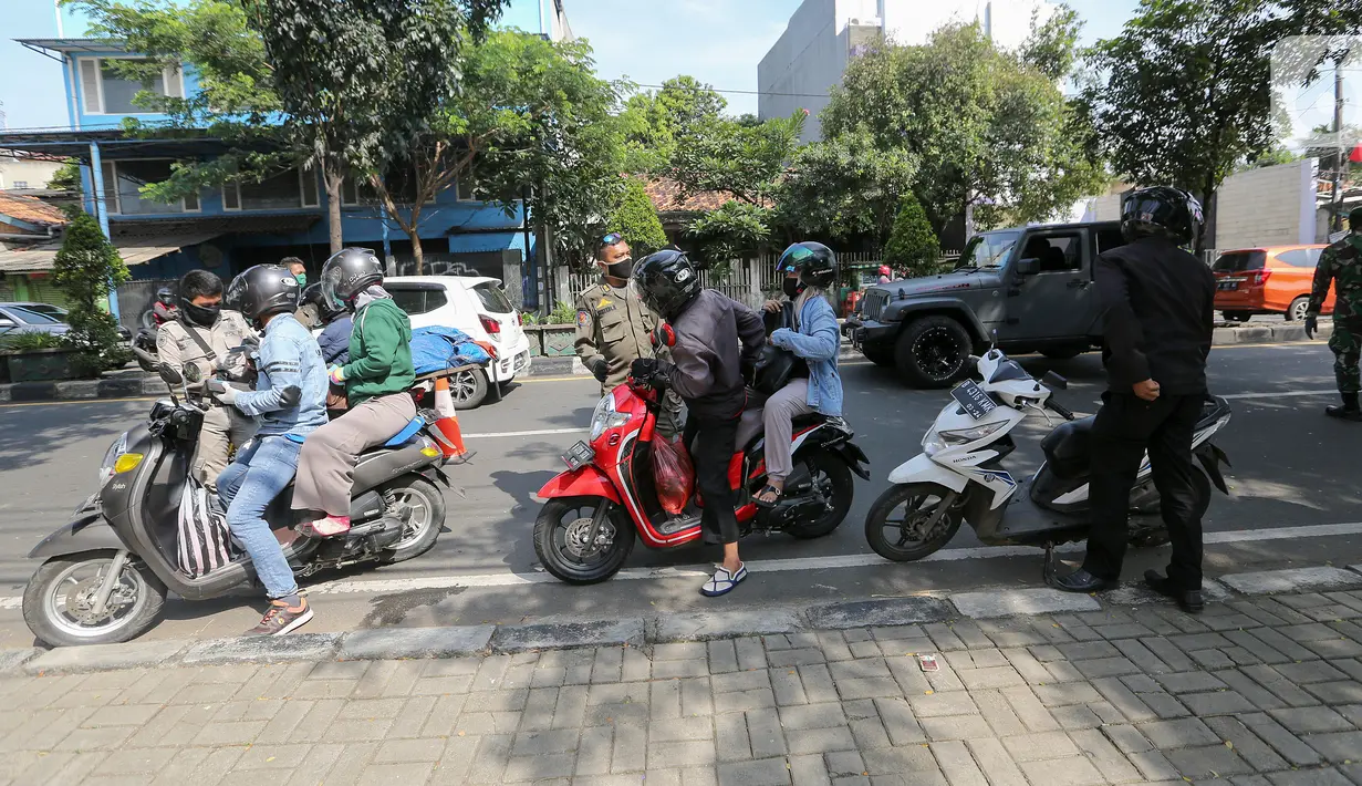 Petugas memeriksa identitas pengendara bermotor pada hari pertama Pemberlakuan Pembatasan Sosial Berskala Besar (PSBB) di jalur check point Jalan Ir. H Juanda, Ciputat, Tangerang Selatan, Sabtu (18/4/2020). Selama PSBB pengendara wajib kenakan masker dan sarung tangan. (Liputan6.com/Fery Pradolo)