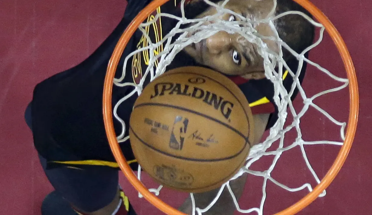 Aksi pemain Cleveland Cavaliers, LeBron James mencetak poin saat melawan Boston Celtics pada gim keempat final Wilayah Timur NBA basketball di Quicken Loans Arena (21/5/2018). Cavaliers menang 111-102. (AP/Tony Dejak)