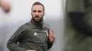 Penyerang Juventus, Gonzalo Higuain melakukan pemanasan saat sesi latihan di pusat pelatihan Juventus di Vinovo (2/4). Juventus akan bertanding melawan Real Madrid pada leg pertama babak perempatfinal Liga Champions. (AFP Photo/Marco Bertorello)