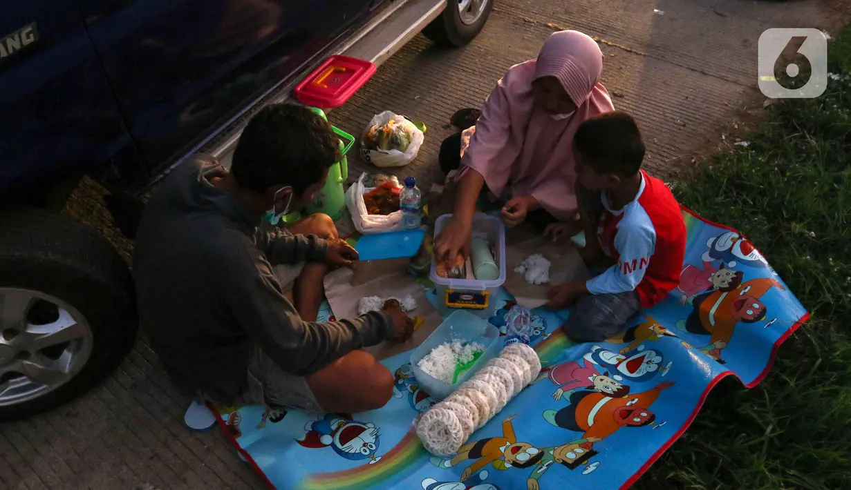 <p>Sejumlah pemudik berbuka puasa Ramadhan sambil beristirahat di KM 102 ruas Tol Cikopo-Palimanan, Subang, Jawa Barat, Kamis (28/4/2022). Padatnya sejumlah rest area di sepanjang jalan tol Trans Jawa membuat pemudik memanfaatkan bahu jalan untuk berbuka puasa dan istirahat sejenak. (Liputan6.com/Herman Zakharia)</p>