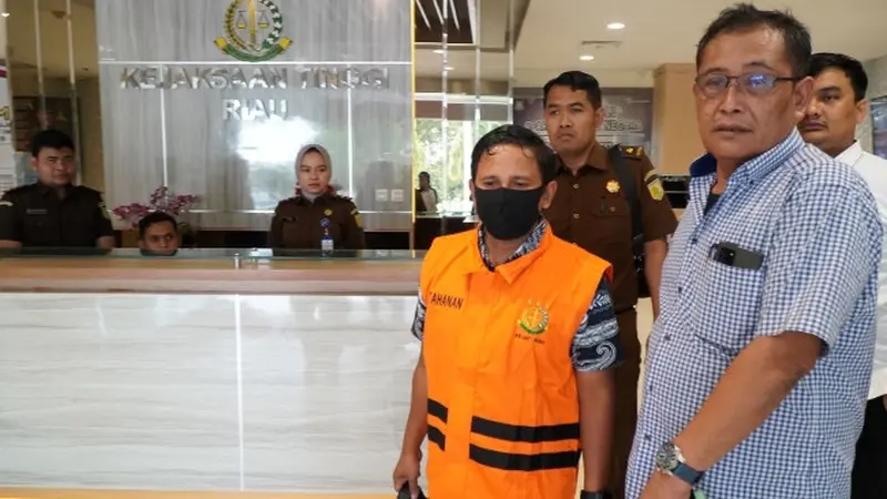 Petugas Kejati Riau menggiring teller dan customer service Bank Riau Kepri Syariah ke mobil tahanan setelah menjadi tersangka korupsi.