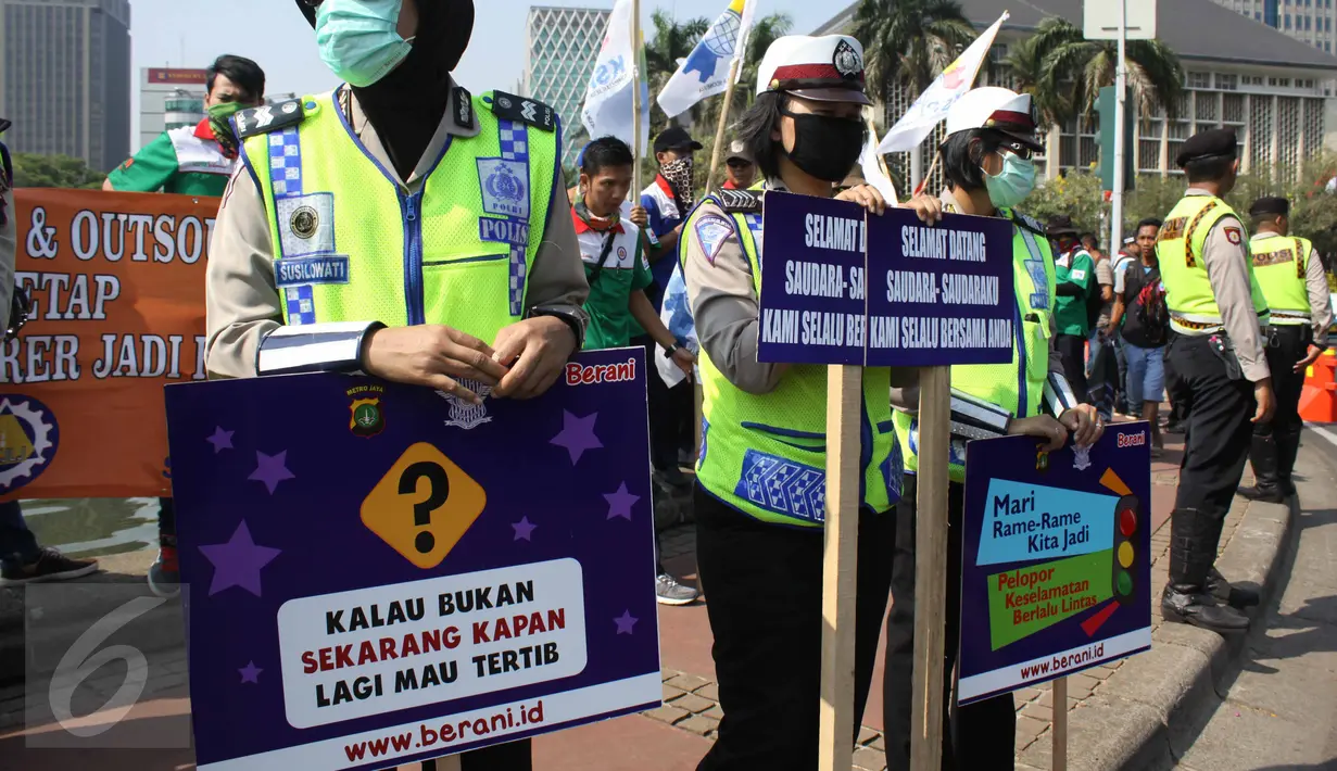 Petugas kepolisian saat mengamankan unjuk rasa buruh di kawasan Patung Kuda, Jakarta, Selasa (1/8/2015). Mereka menuntut pemerintah menghentikan gelombang PHK yang mengancam akibat melemahnya nilai tukar rupiah terhadap dolar.(Liputan6.com/Gempur M Surya)