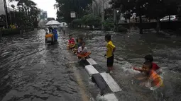 Intensitas curah hujan yang tinggi sejak Minggu (8/1) malam serta sistem drainase yang buruk menyebabkan sejumlah ruas jalan di ibukota terendam banjir, Jakarta, Senin (9/2/2015). (Liputan6.com/Johan Tallo)