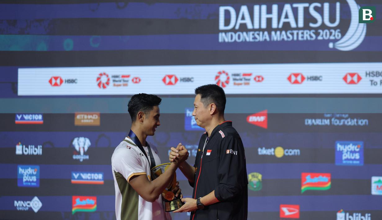 Pebulu tangkis tunggal putra Indonesia, Alwi Farhan bersalaman dengan pelatih Indra Wijaya di atas podium setelah menjuarai Indonesia Masters 2026 di Istora, Senayan, Jakarta, Minggu (25/01/2026). (Bola.com/Bagaskara Lazuardi)