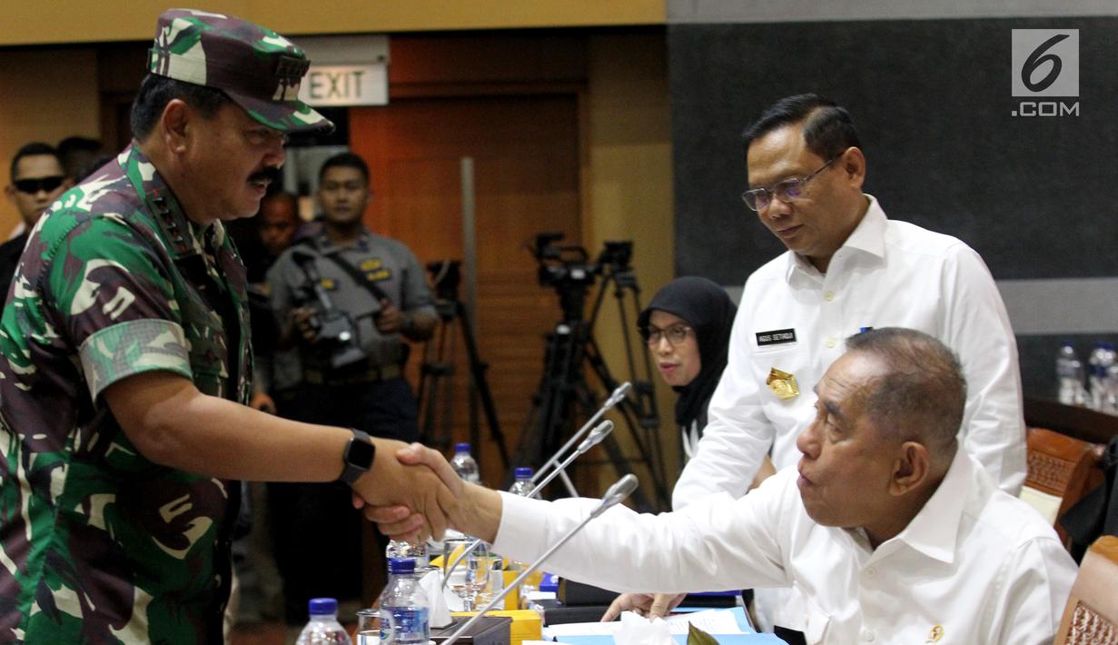 Panglima TNI Marsekal Hadi Tjahjanto (kiri) menyalami Menhan Ryamizard Ryacudu saat rapat kerja dengan Komisi I DPR di Kompleks Parlemen, Jakarta, Rabu (19/6/2019). Rapat juga membahas progres pencapaian MEF TNI Tahun 2014-2019 dan evaluasi pengamanan pasca Pemilu 2019. (Liputan6.com/JohanTallo)