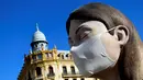 Patung raksasa yang akan ditampilkan di festival Las Fallas atau festival api terlihat mengenakan masker di Valencia, Spanyol, Rabu (11/3/2020). Festival Fallas yang akan berlangsung pada 13 Maret telah dibatalkan karena wabah coronavirus. (AFP/Jose Jordan)