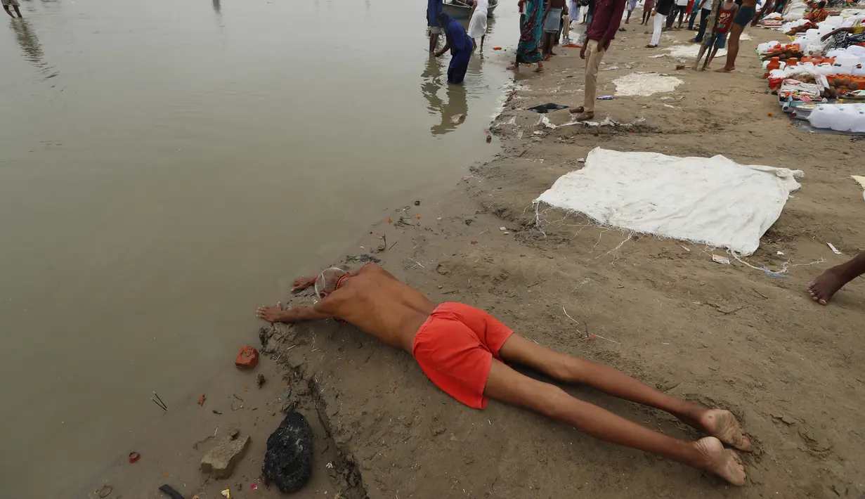 Umat Hindu melakukan ritual selama gerhana matahari di pertemuan Sungai Gangga dan Sungai Yamuna di Sangam, Prayagraj, India, Minggu (21/6/2020). Fenomena gerhana matahari pada 21 Juni 2020 terlihat dari berbagai negara di dunia. (AP Photo/Rajesh Kumar Singh)