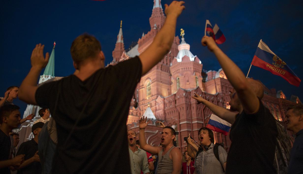 Suporter Rusia berpesta merayakan keberhasilan negaranya mengalahkan Spanyol pada laga 16 besar Piala Dunia di Moskow, Minggu (1/7/2018). Rusia untuk pertama kalinya lolos ke babak perempatfinal. (AFP/Victor Caivano)