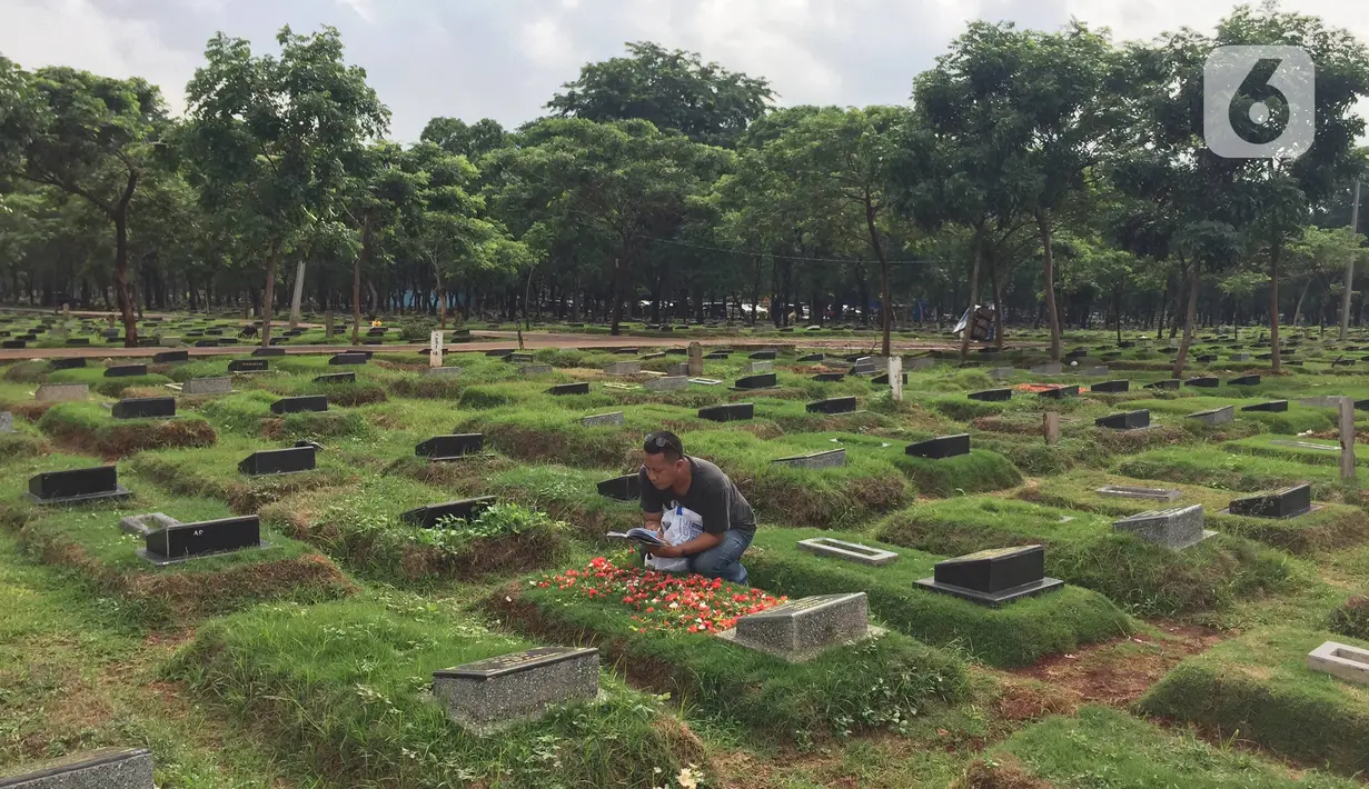 Pelayat memanjatkan doa saat ziarah ke salah satu makam di TPU Pondok Ranggon, Cipayung, Jakarta, Sabtu (28/12/2019). Pengelola TPU Pondok Ranggon mulai memberlakukan tumpang jasad dalam satu liang lahat jelang habisnya masa tampung pada Januari 2020. (Liputan6.com/Immanuel Antonius)