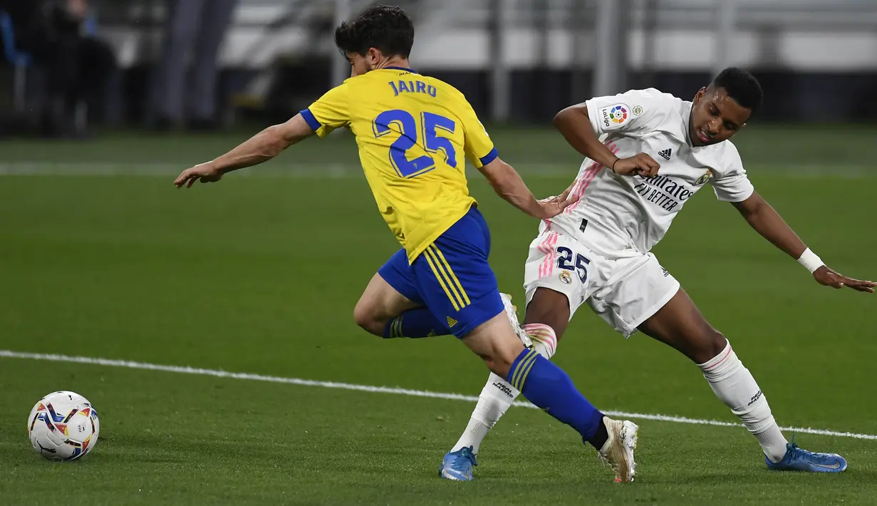 Pemain Real Madrid, Rodrygo, berebut bola dengan pemain Cadiz, Jairo Izquierdo, pada laga Liga Spanyol di Stadion Ramon de Carranza, Rabu (22/4/2021). Real Madrid menang dengan skor 3-0. (AP Photo/Jose Breton)
