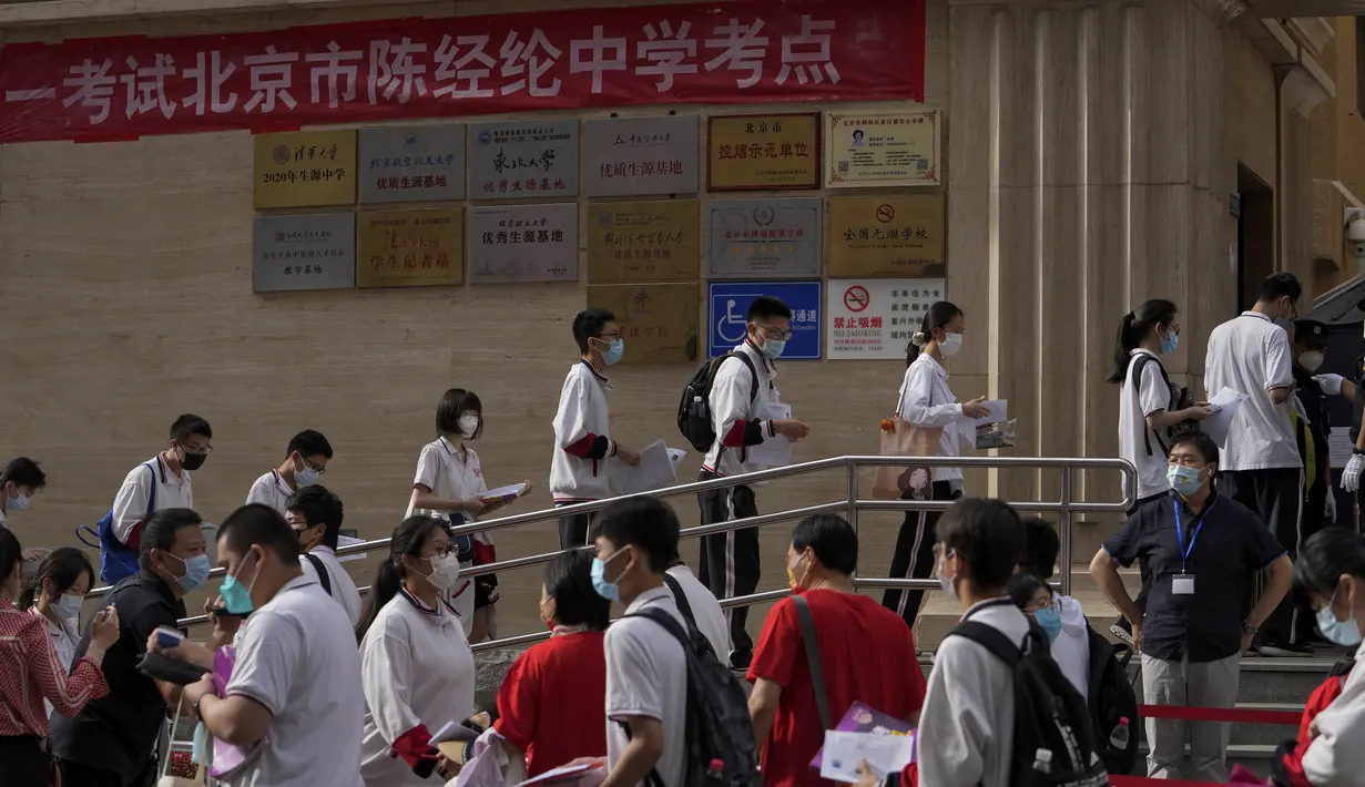 Siswa yang mengenakan masker berbaris untuk memasuki sekolah untuk hari pertama ujian masuk perguruan tinggi nasional China, atau dikenal gaokao, di Beijing, Selasa (7/6/2022). Gaokao merupakan bagian dari sistem pendidikan di China sejak tahun 1950-an, meskipun ada jeda di masa Revolusi Budaya. (AP Photo/Andy Wong)